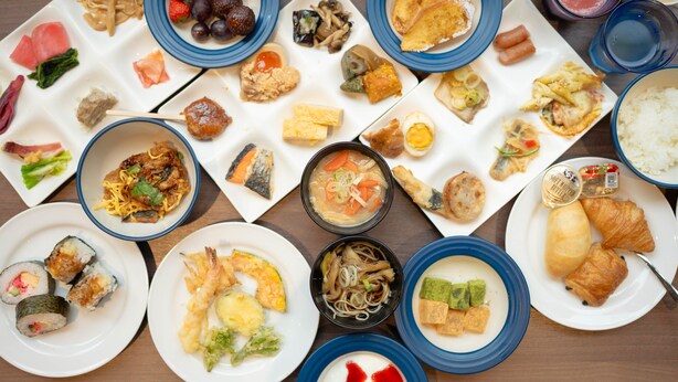 Una variedad de platos dispuestos en una mesa, como sushi, fideos y otras comidas.