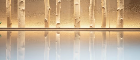 A series of vertical, textured surfaces with a reflective base, likely part of a building's interior design.