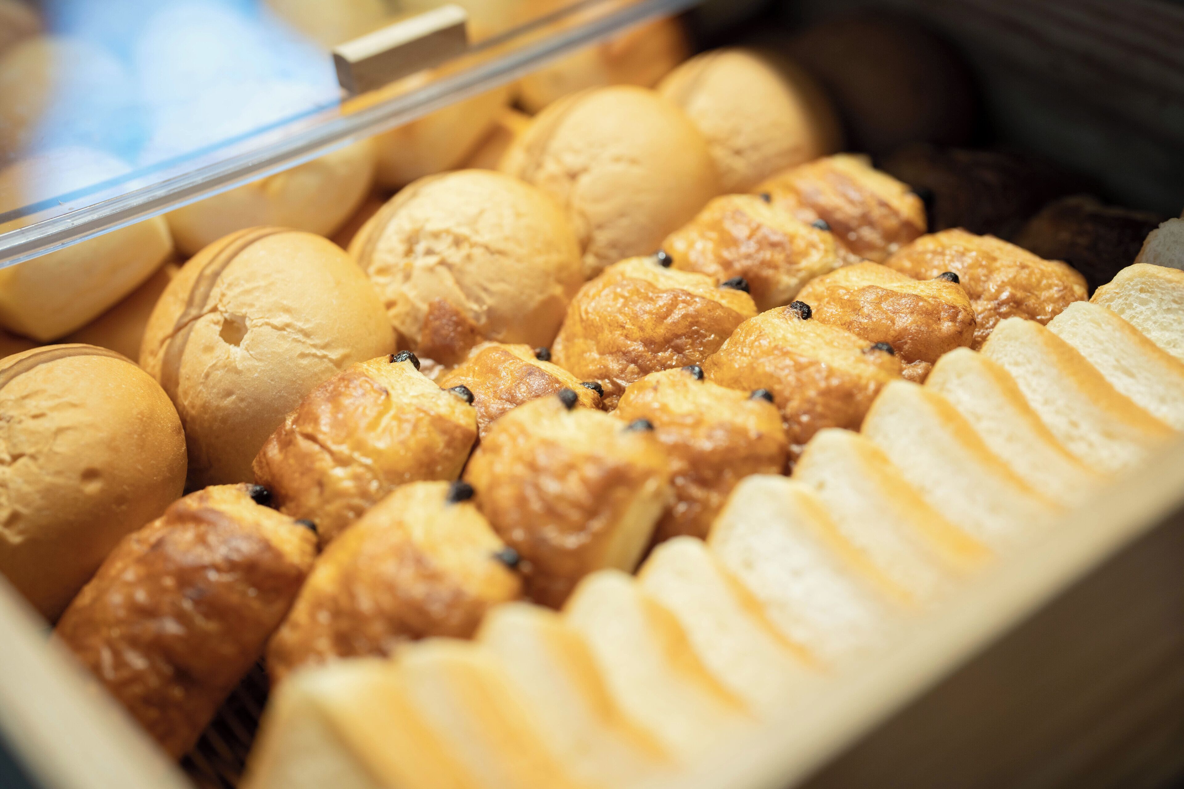 A bakery display case with various baked goods, including pastries and bread.