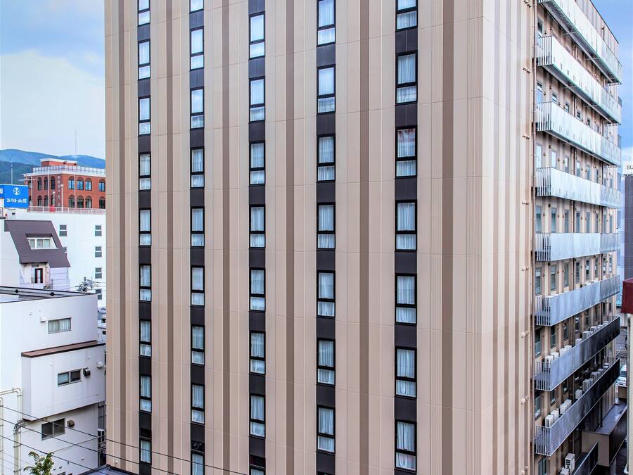 A modern hotel building with a prominent sign reading "Tabinohotel".