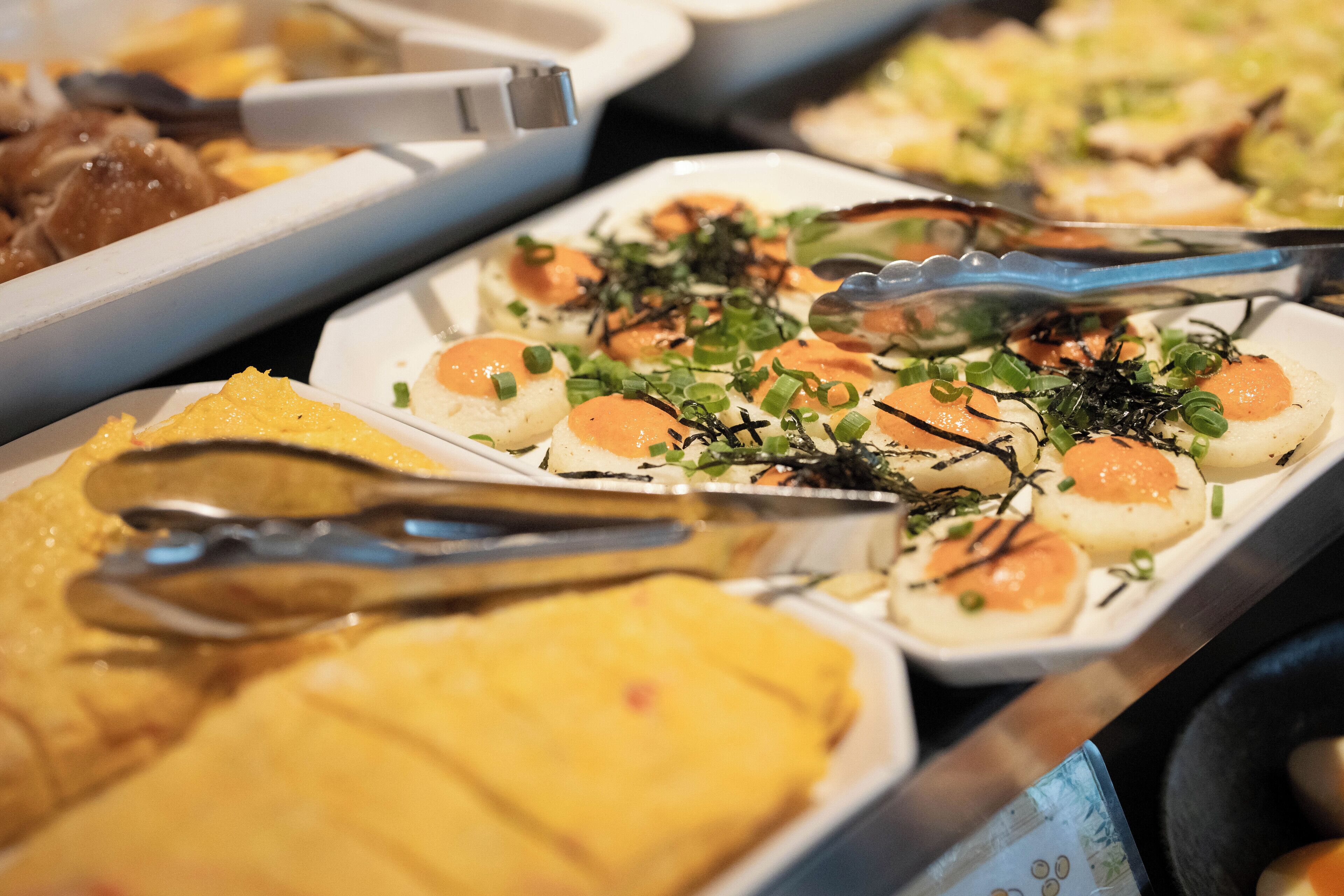 A buffet with various dishes, including seafood and vegetables.