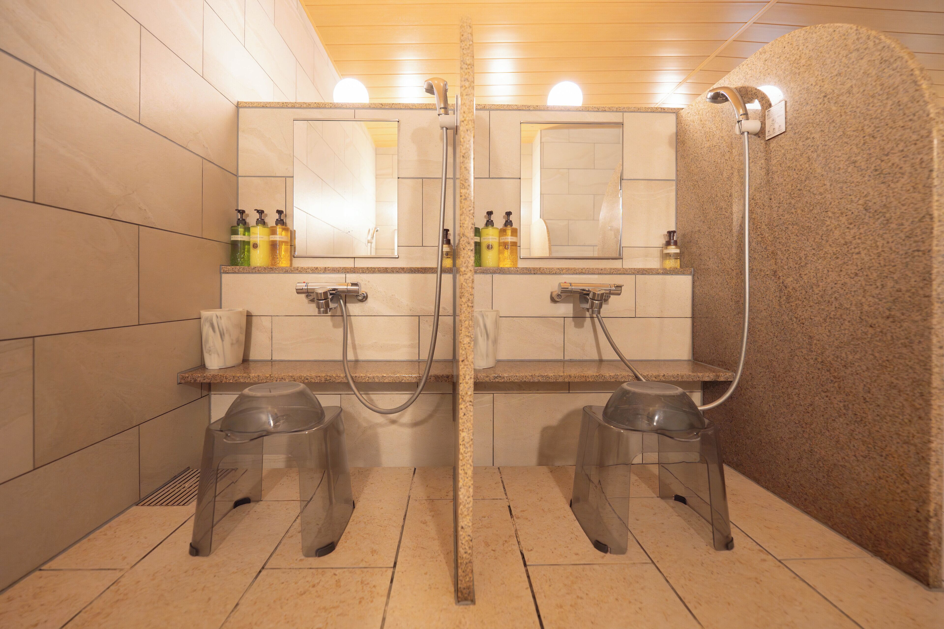 A public restroom with two sinks, mirrors, and a shower area.