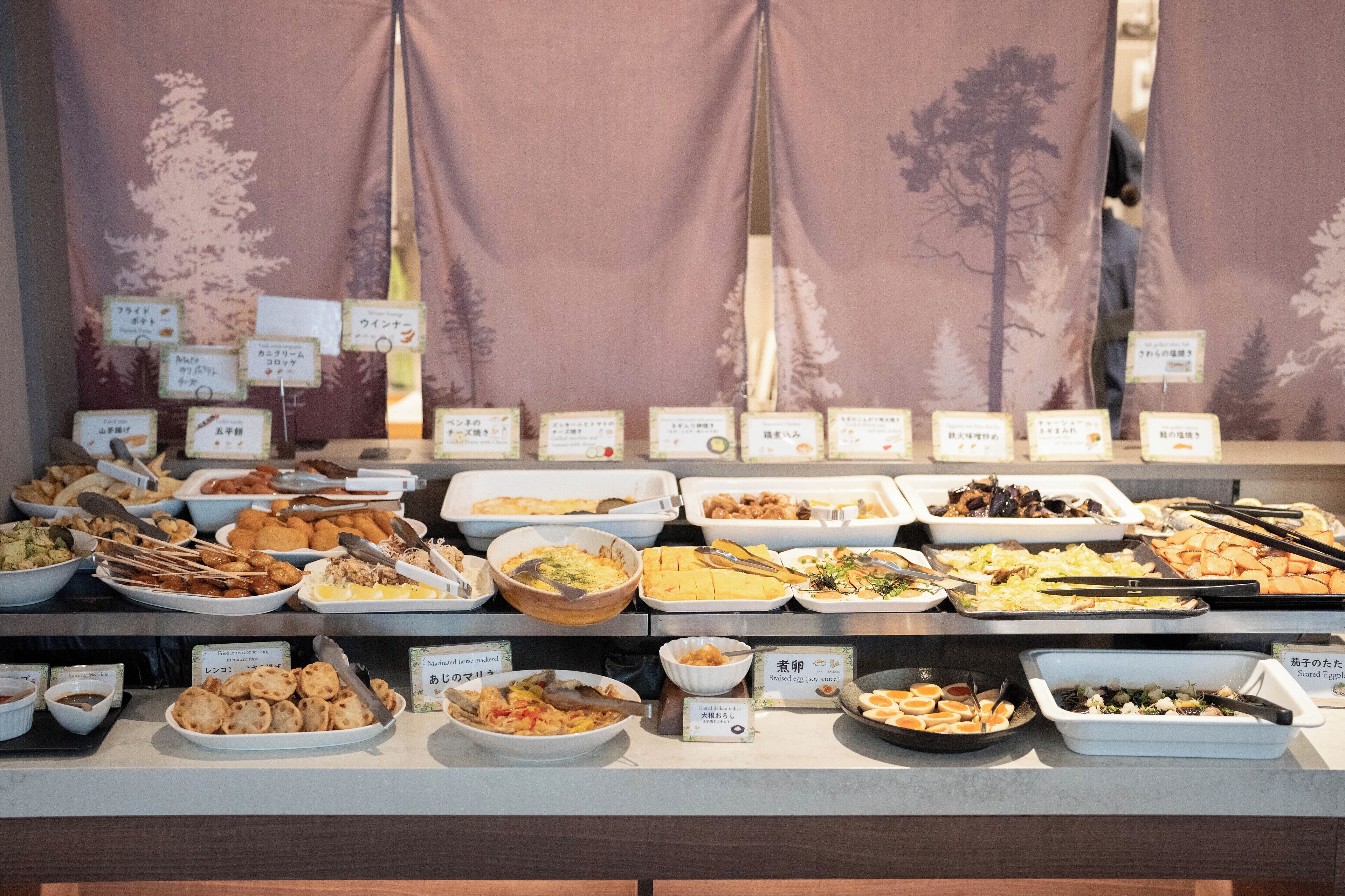 A buffet with various dishes and labels in a foreign language.