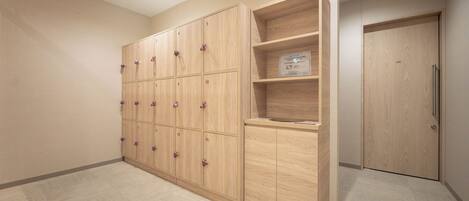 A room with a wooden locker area, a small shelf with a plaque, and a door.