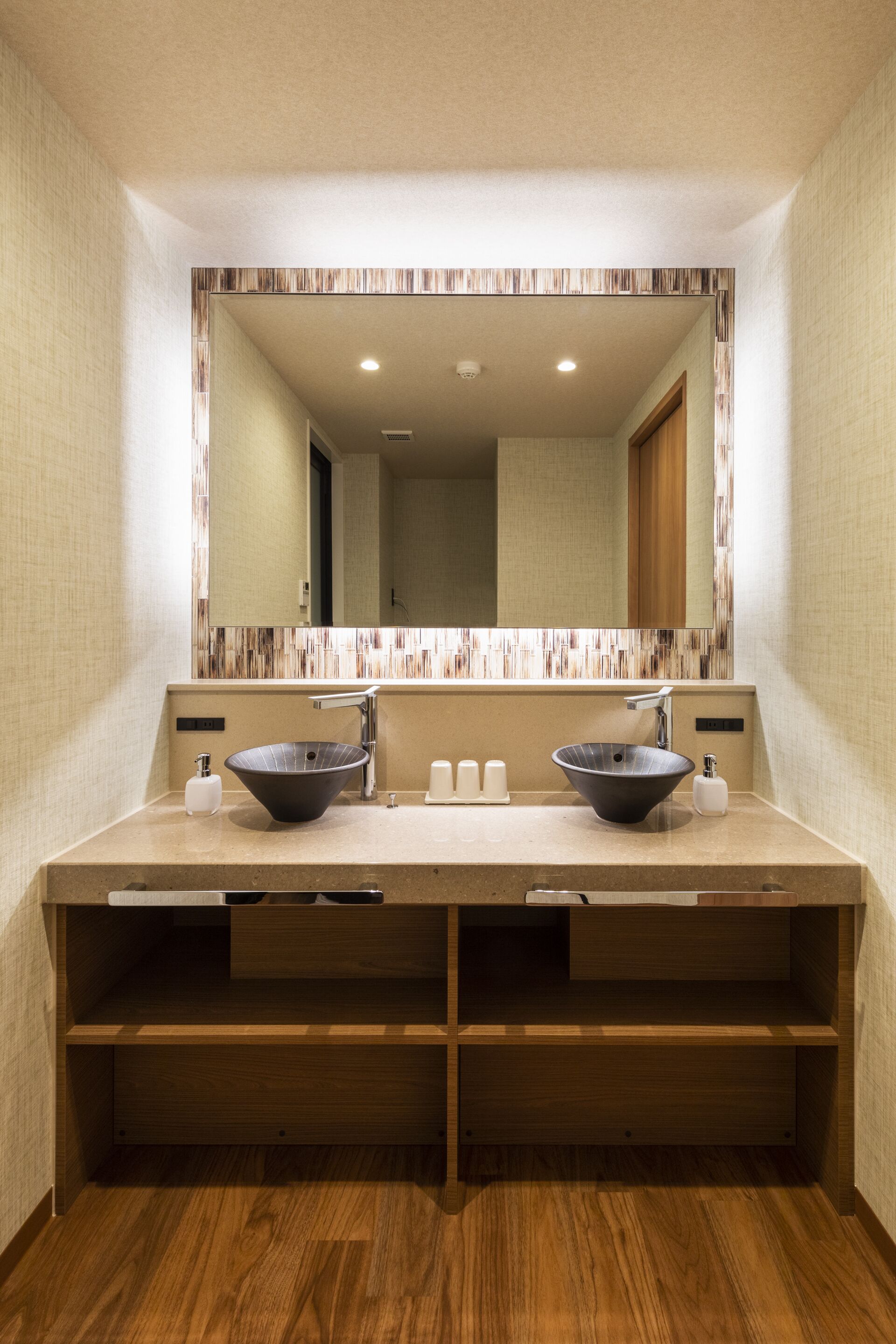 A modern bathroom with two sinks, a large mirror, and wooden shelving.