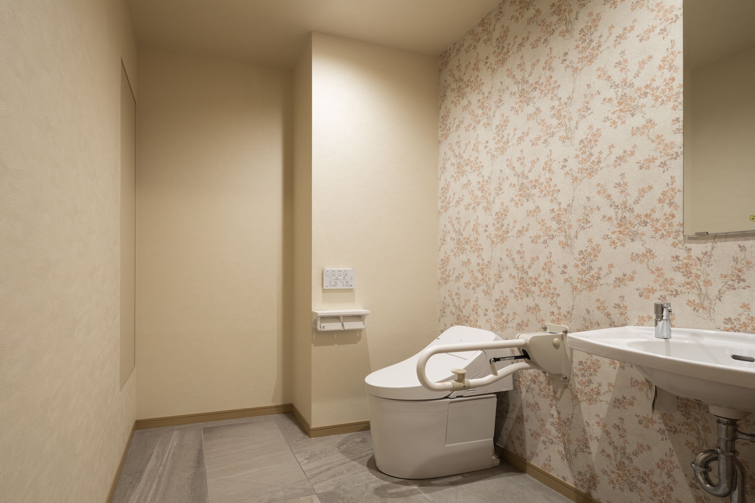 Ein Badezimmer mit Toilette, Waschbecken und einer Steckdose an der Wand.