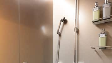 A modern bathroom with a shower, a towel rack, and two shelves with toiletries.