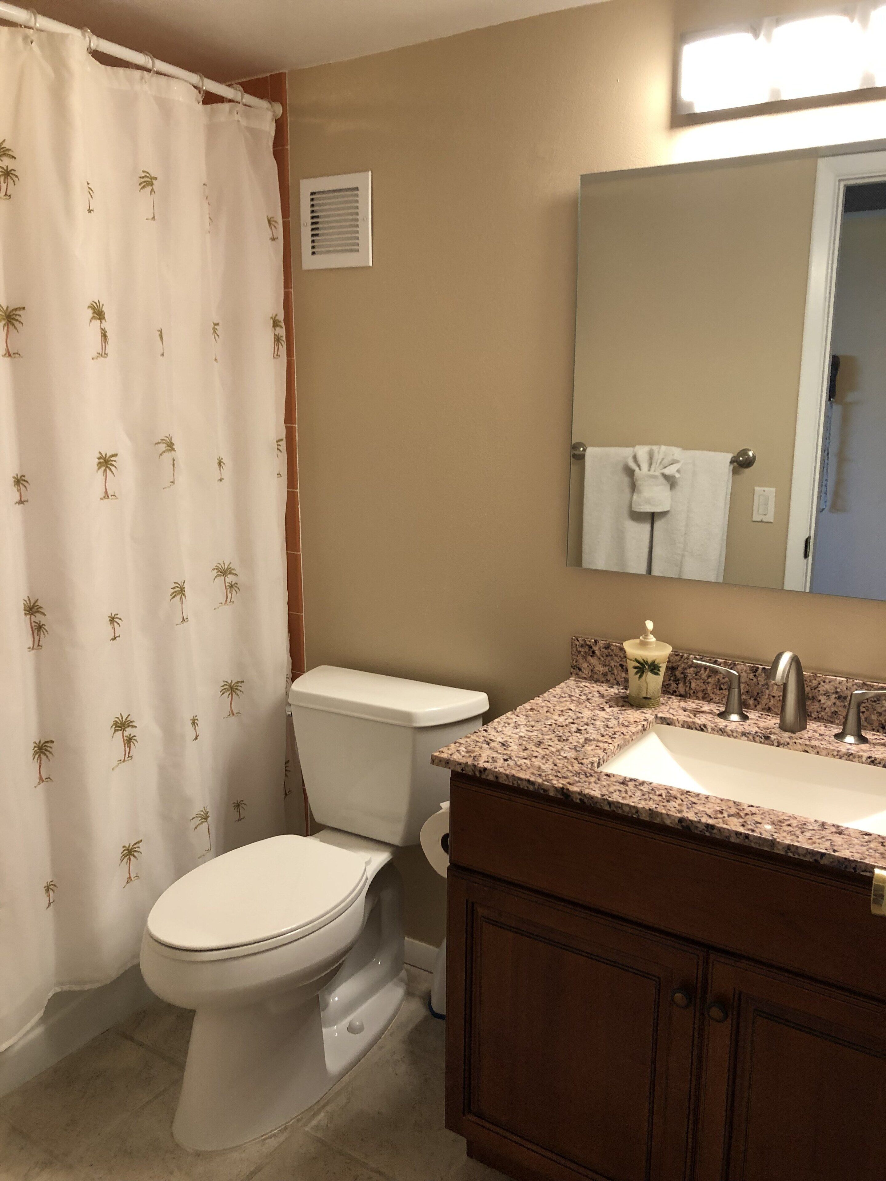 Un baño con inodoro, lavabo y cortina de ducha.