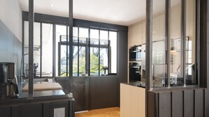 Una cocina moderna con un amplio ventanal, suelo de madera y electrodomésticos integrados.
