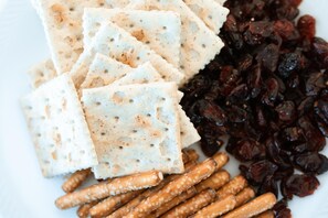 A plate with crackers, pretzels, and raisins. - Elefantino Grey - FAMILY HOTEL (Cervia)