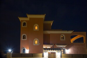 Ein Gebäude mit markanter Architektur, mit Bogenfenstern und einer flachen Dachfläche.