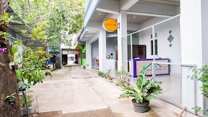 A narrow alleyway with a 'Spot On' sign, potted plants, and a gated entrance to a property.