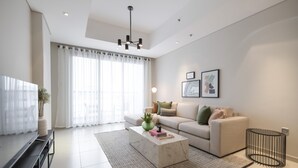 Ein modernes Wohnzimmer mit Sofa, Couchtisch und Fernseher.