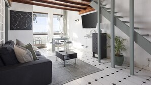A modern living room with a sofa, coffee table, and a staircase.