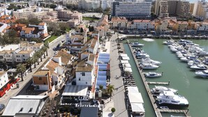 A marina with boats docked along a waterfront promenade.
