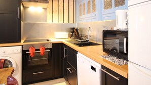 Una cocina compacta equipada con estufa, horno, microondas y cafetera.
