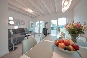Un salon moderne avec une table à manger, un canapé et un saladier rempli de fruits.