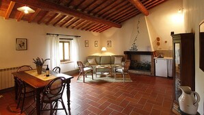 A dining area with a wooden table and chairs, a sofa, and a fireplace. - BLU2 - cozy apartment in the Chianti area with pool (Florence)