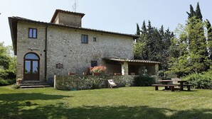 A stone building with a wooden door, a small porch, and a picnic table in the yard. - BLU2 - cozy apartment in the Chianti area with pool (Florence)