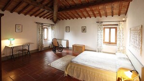 A bedroom with a wooden ceiling, a bed, a chair, a desk, and a radiator. - BLU2 - cozy apartment in the Chianti area with pool (Florence)