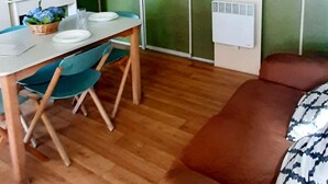 A compact living space with a dining area, kitchenette, and a sofa. - Camping Rianxo (Rianxo)