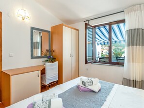 Comfortable retreat with a neatly made bed, desk, and large window.