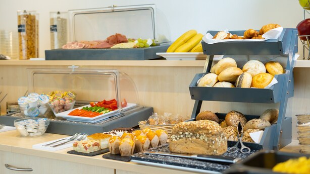 A buffet with various food items including bread, pastries, and fruits. - Taste Smart Hotel Backnang (Backnang)