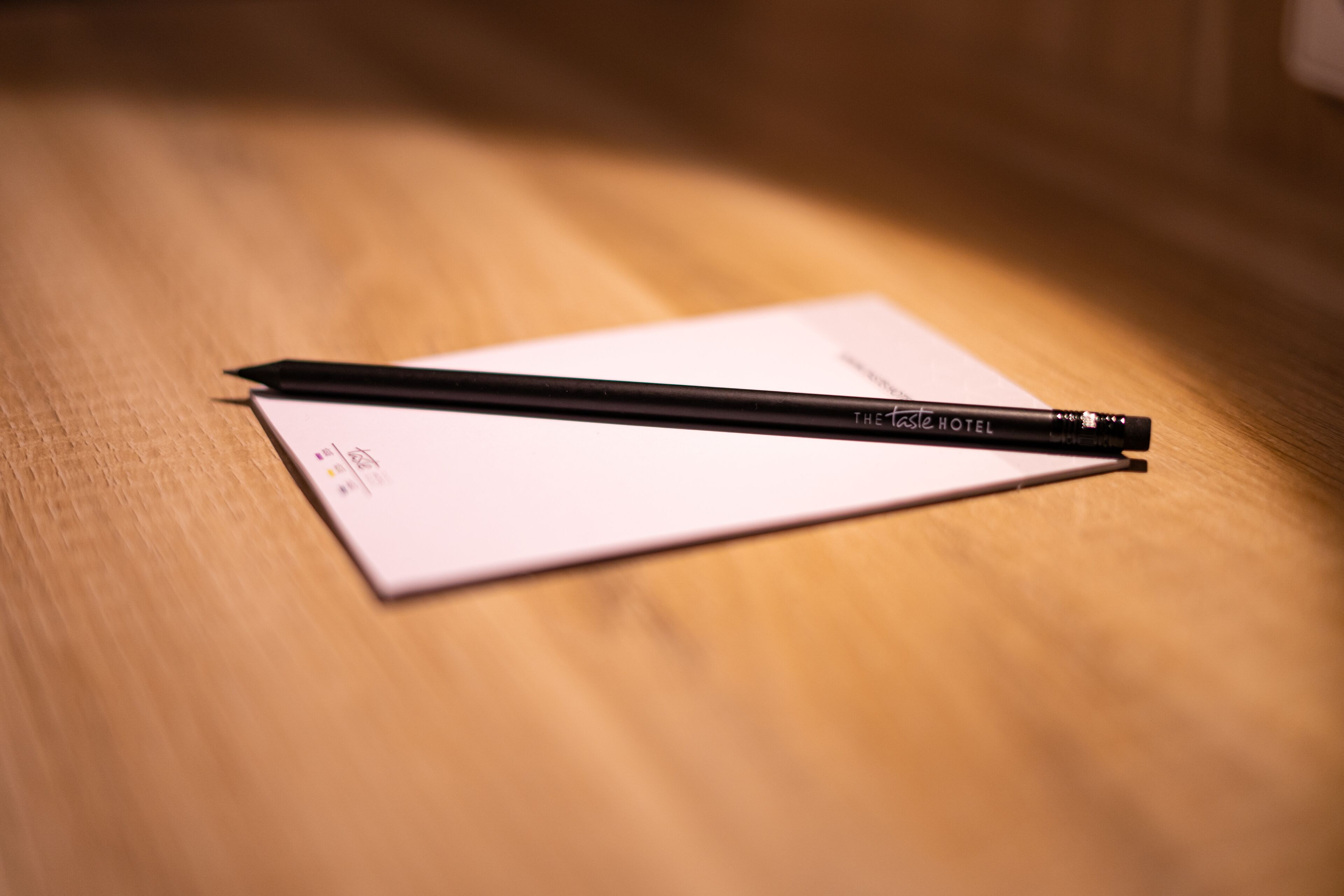 A black pen on a white piece of paper on a wooden surface.