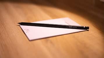 A black pen on a white piece of paper on a wooden surface.
