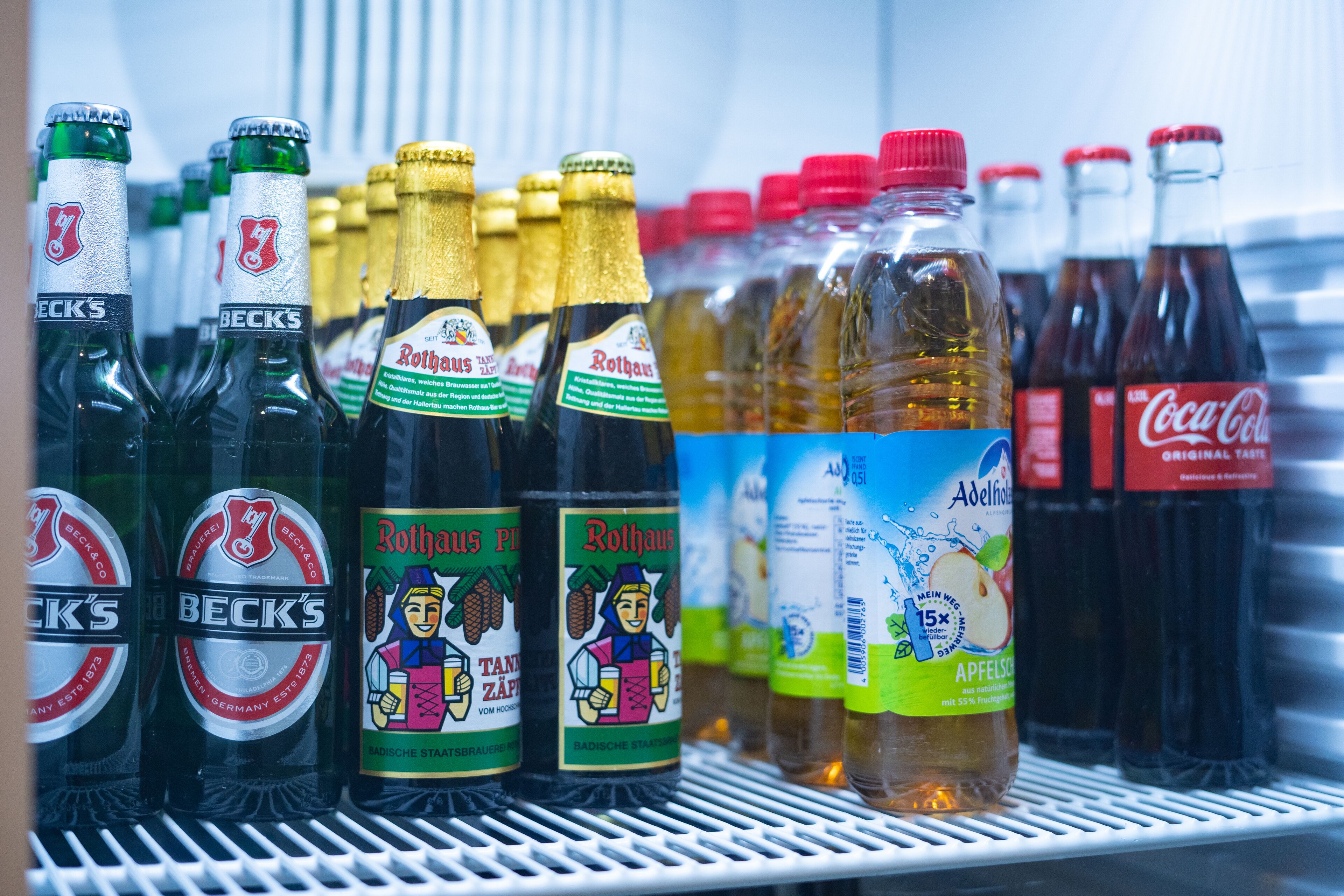 A refrigerator stocked with various beverages including Beck's beer, Rotthaus, and Coca-Cola.