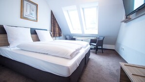 A hotel room with a bed, a desk, and a television. - Taste Smart Hotel Backnang (Backnang)