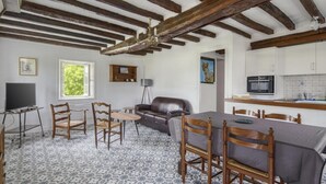 A cozy living room with a fireplace, wooden furniture, and a tiled floor.