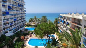 Un hôtel doté de nombreux balcons, d’une piscine et offrant une vue sur la mer.