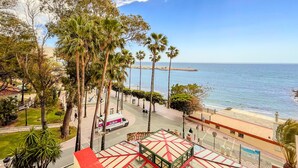Zona costera con palmeras, una playa y cielo despejado.