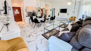 A modern living room with a sofa, a coffee table, and a dining area with chairs and a table. - Skol 326 - Attractive 1 Bed Apartment with Sea View in Skol Marbella (Marbella)