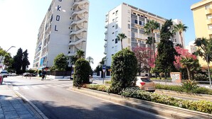 A multi-story building with balconies and a sign reading "SKOL". - Skol 427 - Spacious 1-Bedroom Apartment with Sea Views in Skol Marbella (Marbella)
