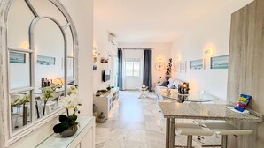 A modern kitchen with a marble countertop, a large mirror, and a dining area with a glass table. - Skol 438 - Lovely 1 Bed Apartment with Wi-Fi + Sea Views in Skol Marbella (Marbella)