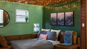 A cozy room with a bed, a seating area, and a small table. - Dreamy Forest Vibe Loft for Couples, Deck and Parking (Pittsburgh)