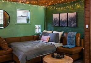 Ein gemütliches Zimmer mit einem Bett, einer Sitzecke und einem kleinen Tisch.