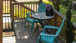 A wooden deck with a round table and two chairs, a potted plant, and a small tree. - Dreamy Forest Vibe Loft for Couples, Deck and Parking (Pittsburgh)