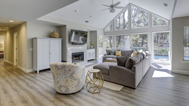 A spacious living area with a large window, a fireplace, and a modern sofa. - New Listing Wonderful Updated Home. Bikes & Beach Gear included (Hilton Head Island)