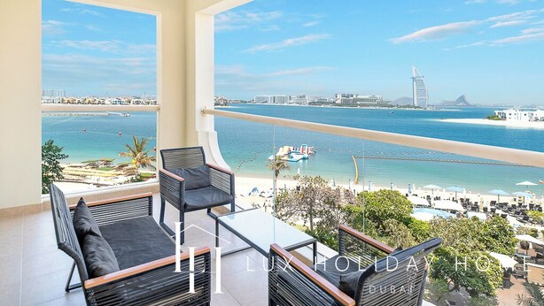 Ein Balkon mit Blick auf das Meer und die Stadt, darunter ein markantes Gebäude.