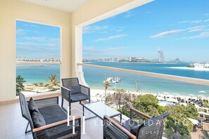 A balcony with a view of the sea and a cityscape, including a distinctive building. - LUX Holiday Home - Al Nabat 1 (Dubai)