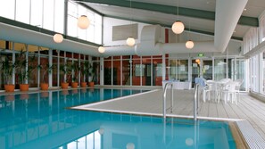 Relax by the pool surrounded by lush greenery and natural light.