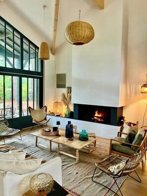 A spacious living room with a fireplace, large windows, and modern furniture. - Modern Villa with Cap Ferret feeling A0306 (Lège-Cap-Ferret)