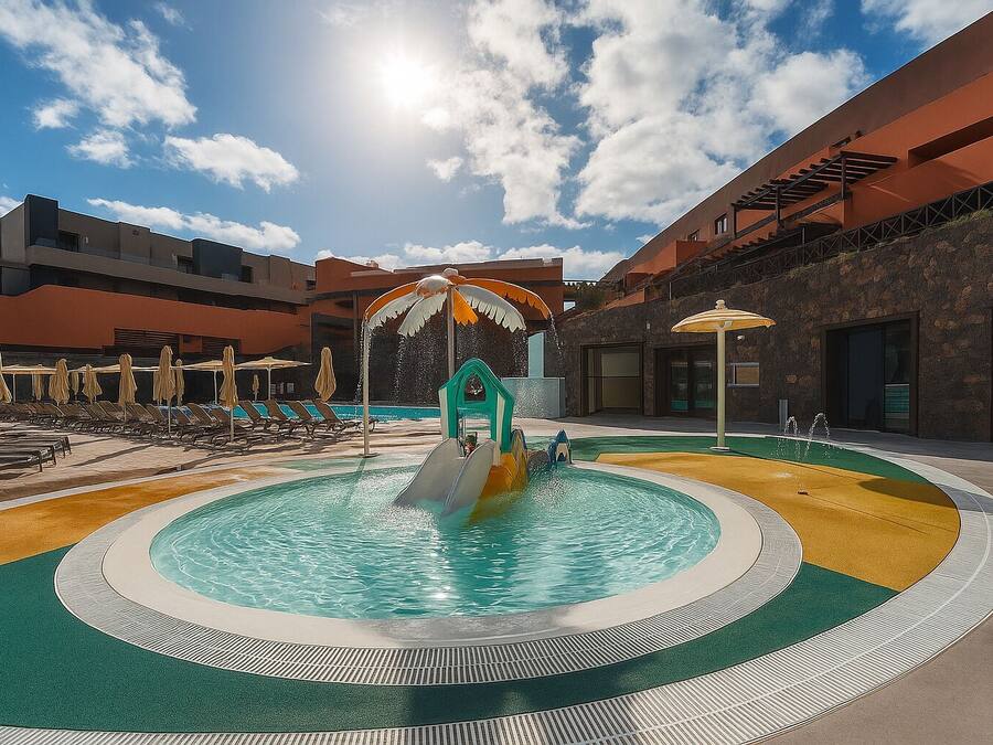 Uma piscina com escorrega, espreguiçadeiras e guarda-sóis.