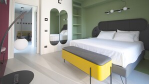 Une chambre à coucher moderne avec un grand lit, un banc et un miroir.