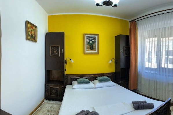 A room with a bed, a wardrobe, a painting, and a window with curtains. - Unique Old Town Home 2min to Beach & Harbour (Constanta)