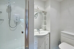 Bathtub, hair dryer, towels, toilet paper