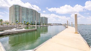 Ein Hotel am Wasserufer mit einer Marina, einer langen Pier und einer Brücke im Hintergrund.